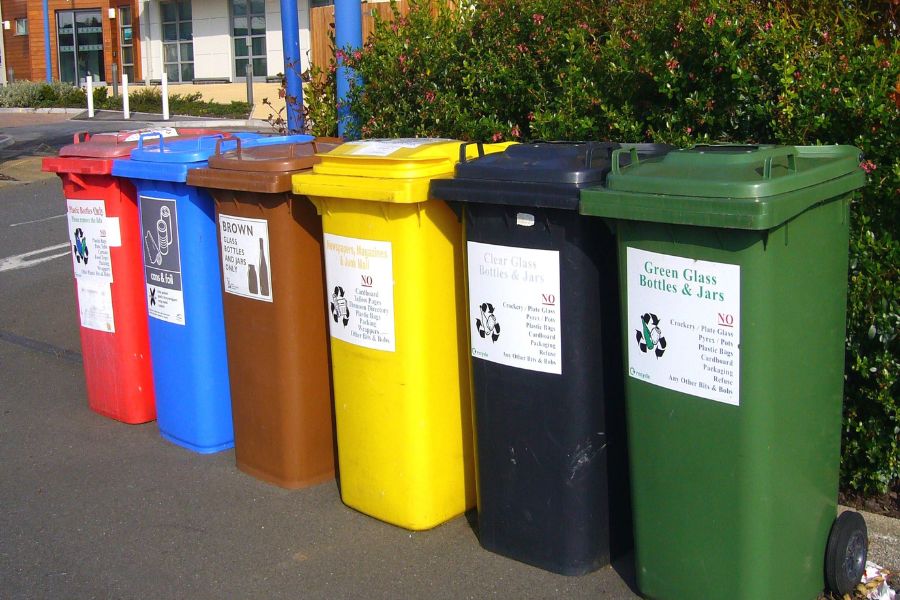a row of colored recycling bins
